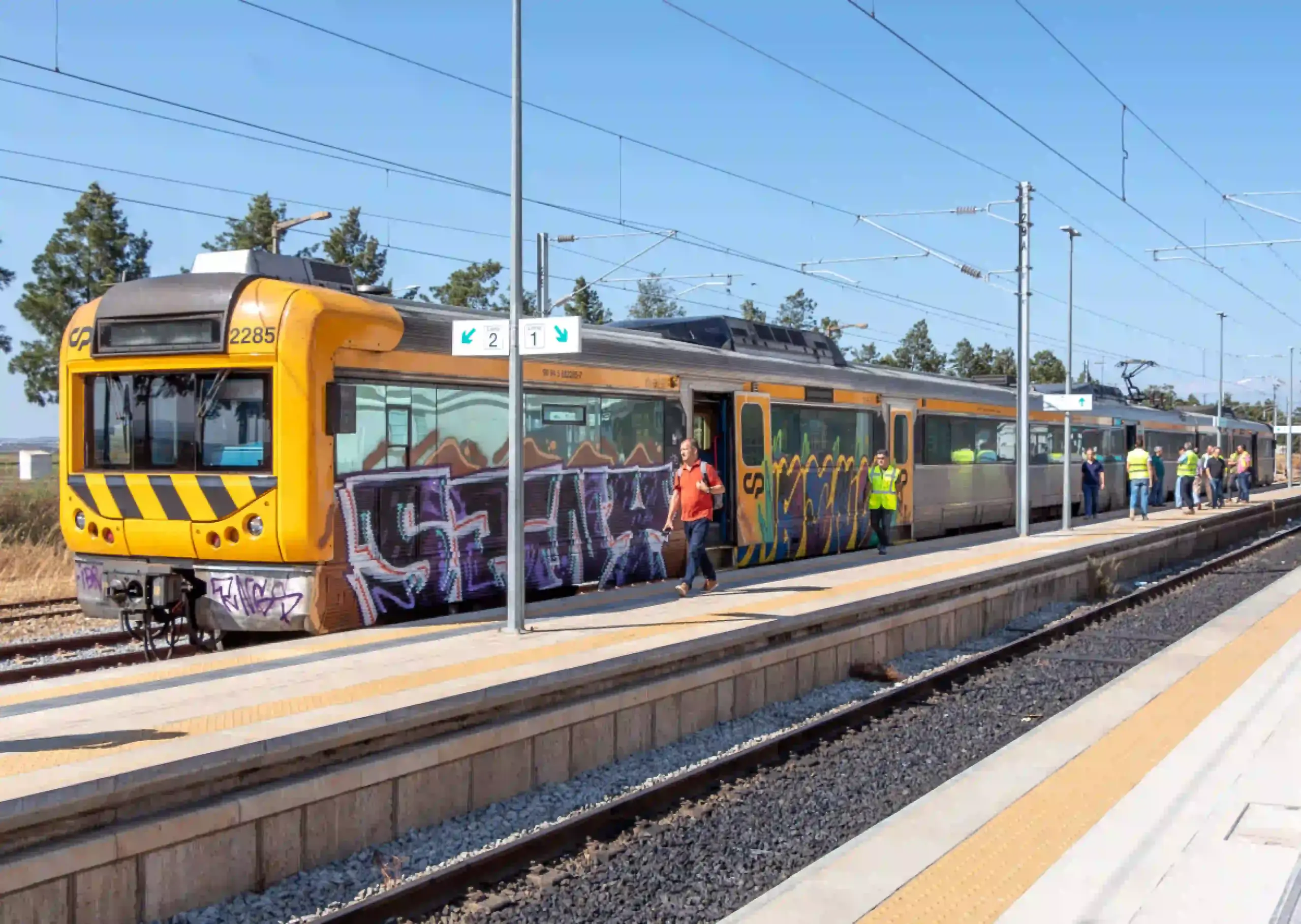 Tren eléctrico de Comboios de Portugal (CP) en la estación de Vila Real de Santo António, con varios trabajadores y visitantes en el andén durante la llegada del primer tren eléctrico procedente de Faro.